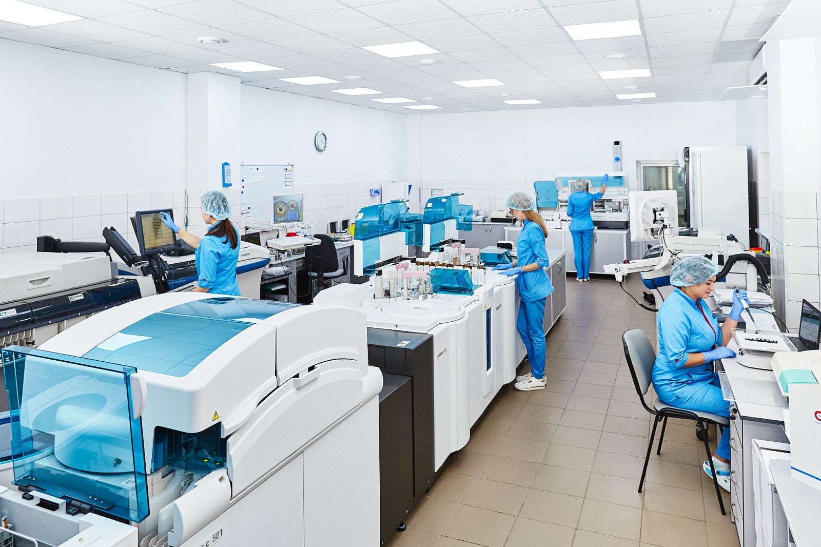 Scientists supervising analytical instruments and computer systems in a modern laboratory