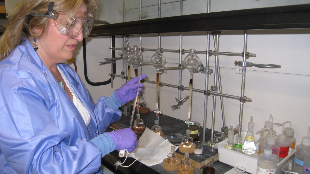 Scientist separating petroleum samples with liquid chromatography columns in a laboratory