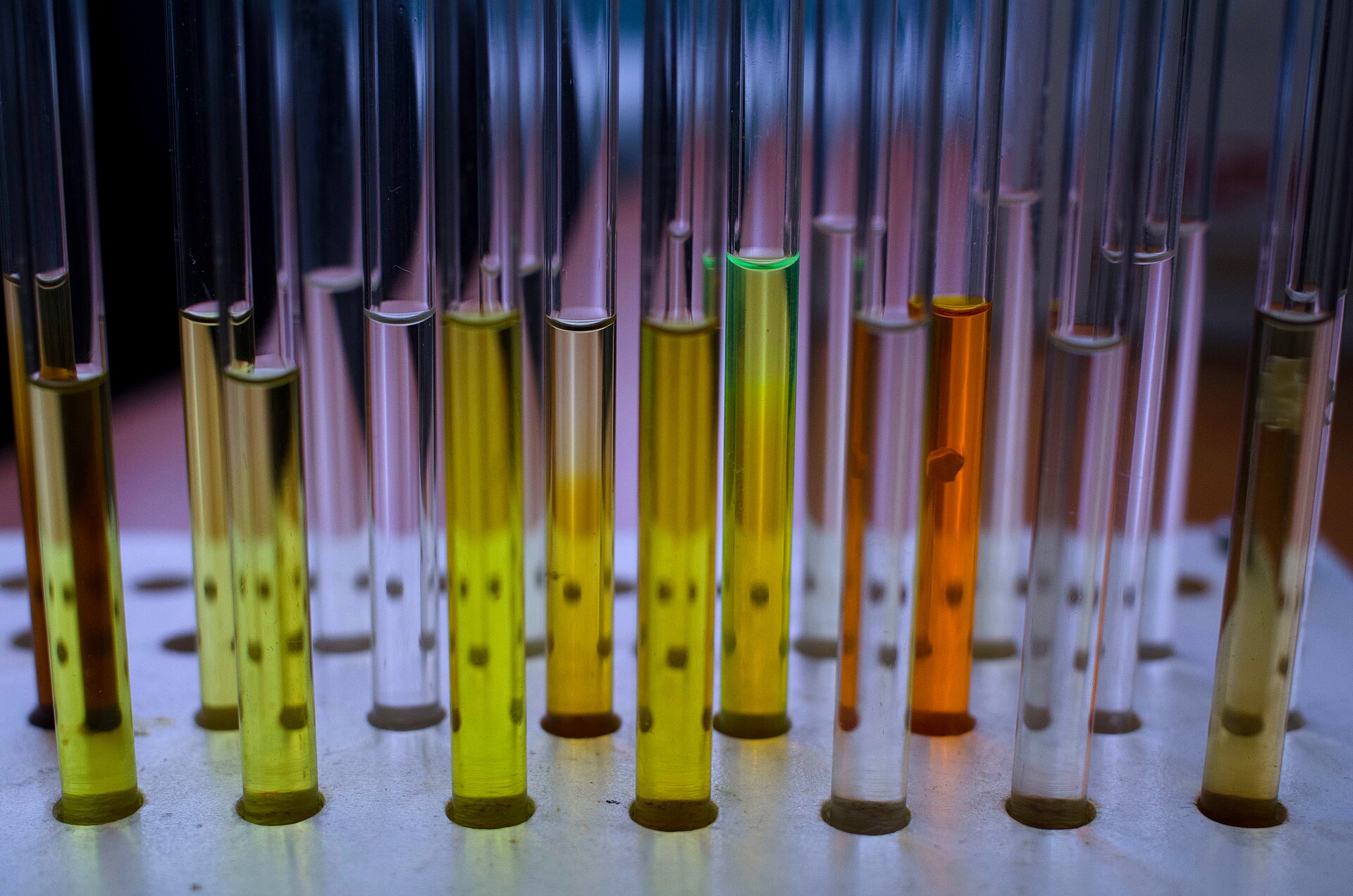 Rack of NMR tubes holding coloured solutions of organic compounds prepared for NMR acquisition